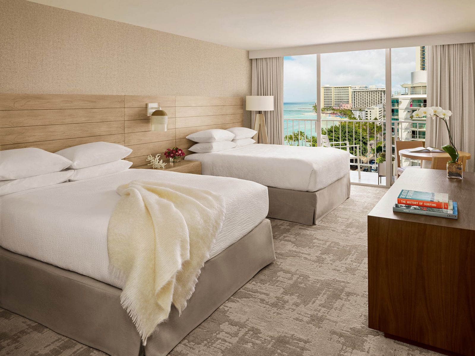 Ocean View room with 2 Queen Beds and view of ocean and Waikiki through sliding glass doors to lanai.